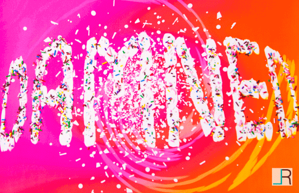 The word Damned made of mashmellows, layered with sprinkles on a pink orange background